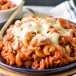 A delicious, cheesy cavatini dish featuring layers of pasta, savory meats, rich tomato sauce, and melted mozzarella and Parmesan cheese.