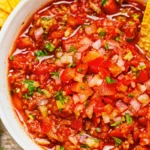 Homemade salsa recipe with fresh tomatoes served in white bowl with tortilla chips