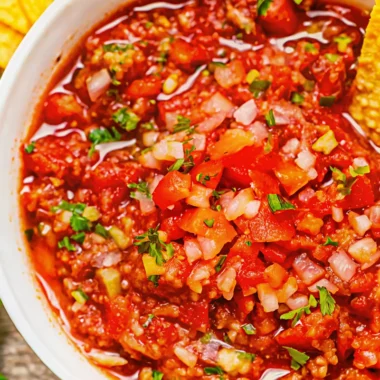 Homemade salsa recipe with fresh tomatoes served in white bowl with tortilla chips