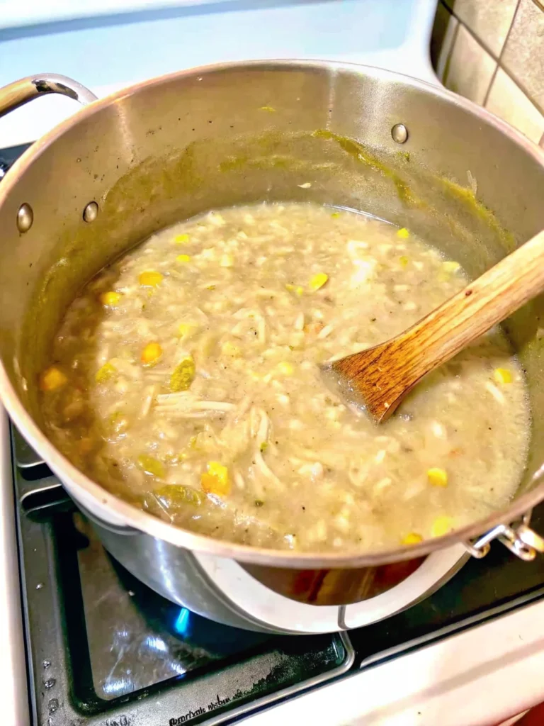 Two bowls of homemade white chicken chili with creamy broth, tender chicken pieces, white beans, corn kernels, and fresh herb garnish