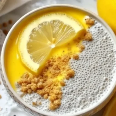 Lemon Cheesecake Overnight Oats served in mason jars with graham cracker topping and fresh lemon
