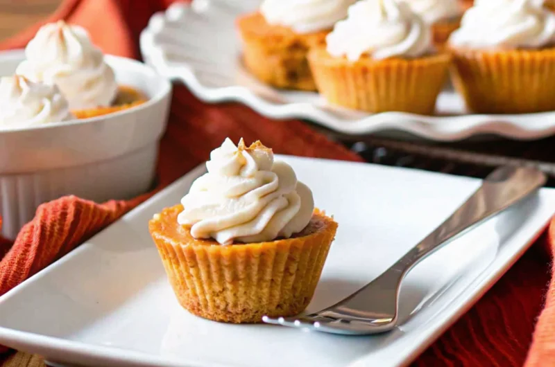 Keto pumpkin recipe mini pies with almond flour crust and sugar-free whipped cream on white plate