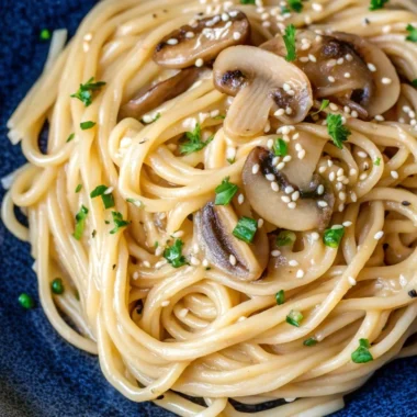 Creamy miso udon noodles in white bowl with coconut milk sauce, garnished with green onions, showing thick wheat udon noodles coated in rich golden miso broth