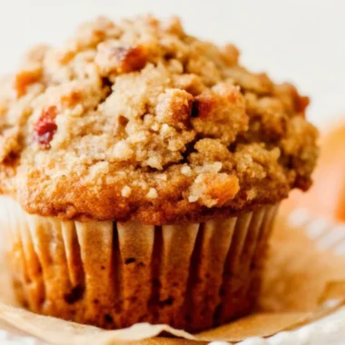 Freshly baked pumpkin muffins with golden apple streusel topping cooling on wire rack, perfect fall breakfast treat