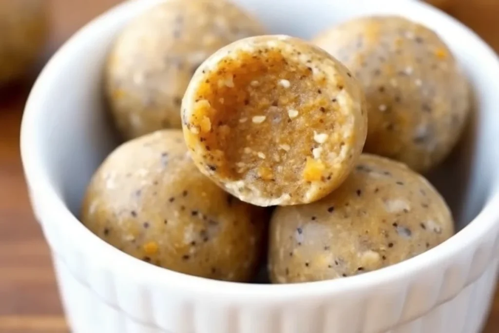 No-bake pumpkin energy balls on parchment paper with fall spices and ingredients, healthy pumpkin pie flavored snacks