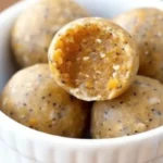 No-bake pumpkin energy balls on parchment paper with fall spices and ingredients, healthy pumpkin pie flavored snacks