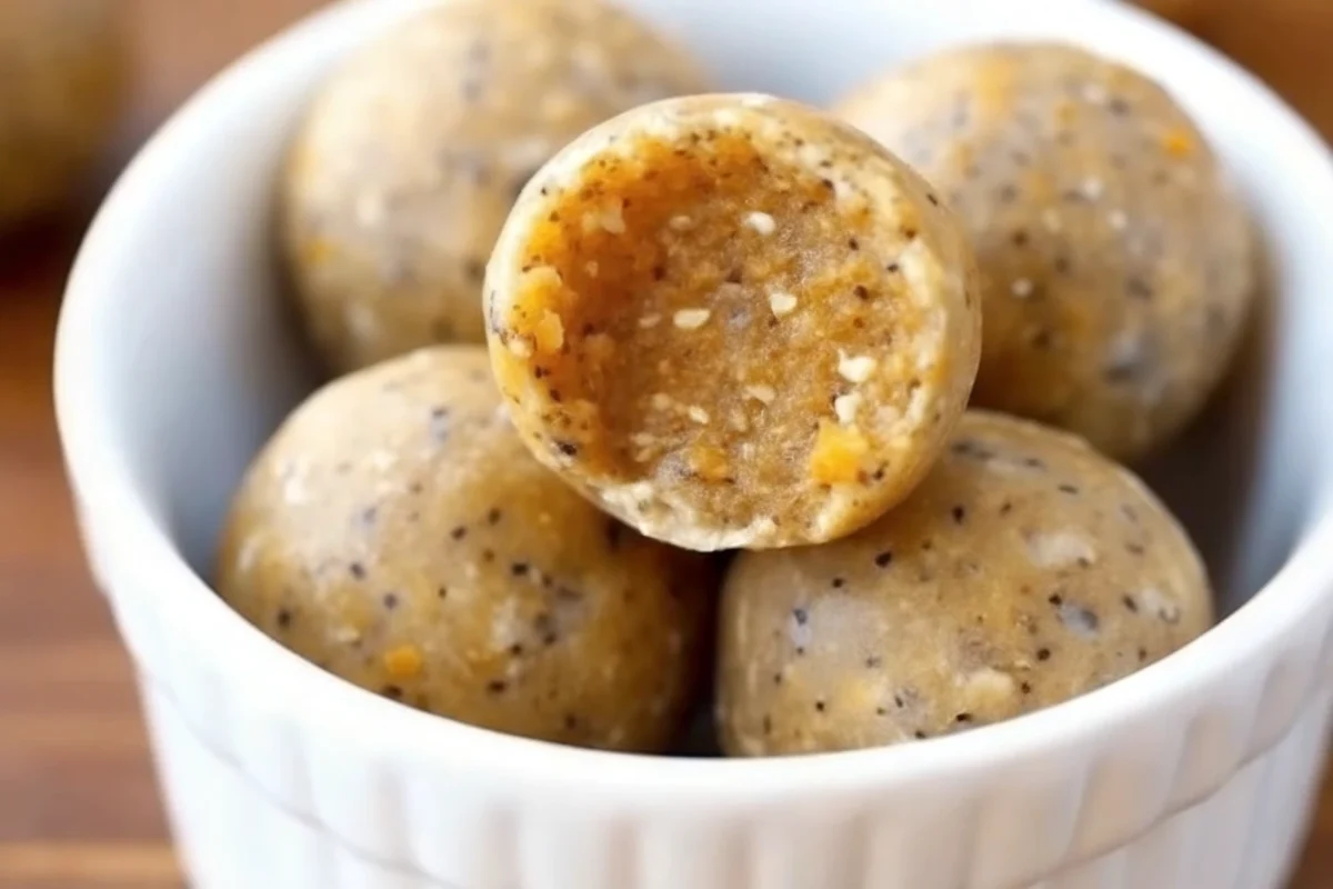 No-bake pumpkin energy balls on parchment paper with fall spices and ingredients, healthy pumpkin pie flavored snacks