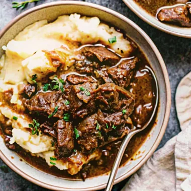 Tender Instant Pot beef tips in rich brown gravy served over mashed potatoes - easy instapot recipe for comfort food dinner