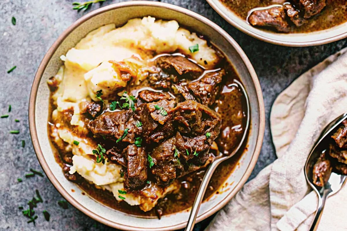 Tender Instant Pot beef tips in rich brown gravy served over mashed potatoes - easy instapot recipe for comfort food dinner