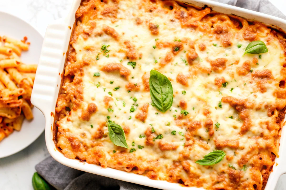 Homemade baked ziti with Italian sausage, ricotta cheese, and melted mozzarella in casserole dish