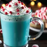 Jack Frost’s Frosted Christmas Cocoa in a festive mug, featuring peppermint white chocolate drink with blue food coloring, whipped cream topping, and crushed candy garnish – perfect for holiday cocoa recipe ideas.